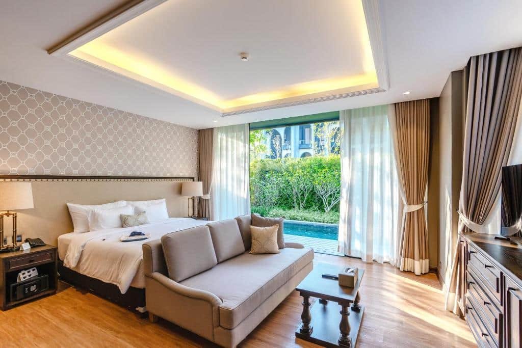 ห้องพักโรงแรมสมัยใหม่พร้อมเตียงขนาดใหญ่ โซฟา ทีวี และโต๊ะกาแฟ; ประตูบานเลื่อนกระจกเปิดออกสู่ระเบียงที่มีสระว่ายน้ำส่วนตัวขนาดเล็กและวิวสวน—เหมาะสำหรับการพักผ่อนหลังเที่ยวเขาใหญ่.