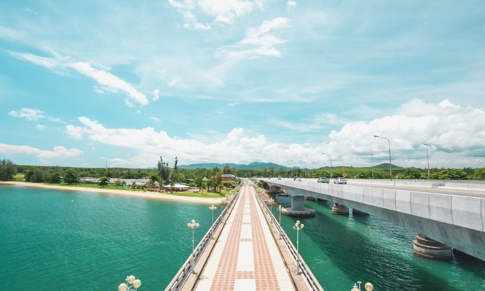 เส้นทางสำหรับ สะพานสารสิน คนเดินเท้าทอดขนานไปกับสะพานสะพานสารสินเหนือผืนน้ำสีฟ้าใส พร้อมทิวทัศน์อันงดงามที่มีต้นไม้เขียวขจีและภูเขาเป็นฉากหลังภายใต้ท้องฟ้าสีฟ้าใส