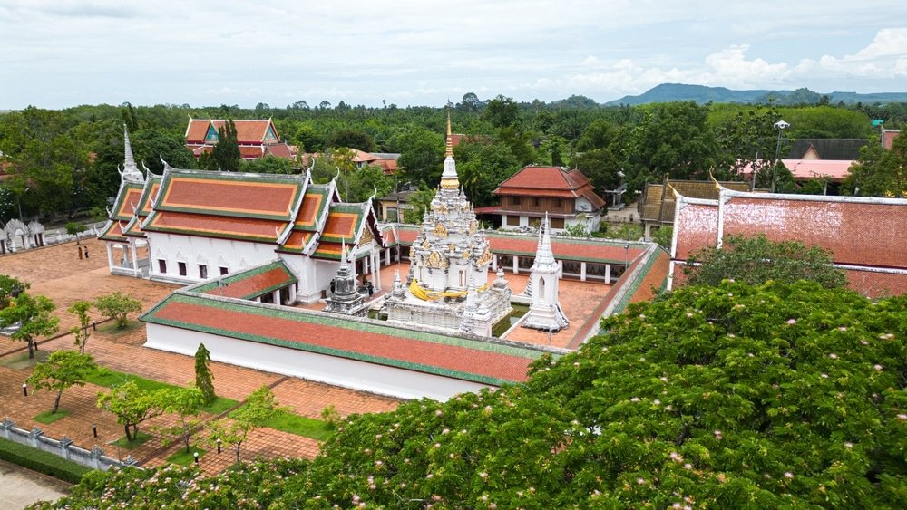 มุมมองทางอากาศ เขื่อนเชี่ยวหลาน ของวัดไทยโบราณที่ซับซ้อนพร้อมอาคารหรูหราตั้งอยู่ท่ามกลางแมกไม้เขียวขจี ไม่ไกลจากความงามอันเงียบสงบของเขื่อนเชี่ยวหลาน