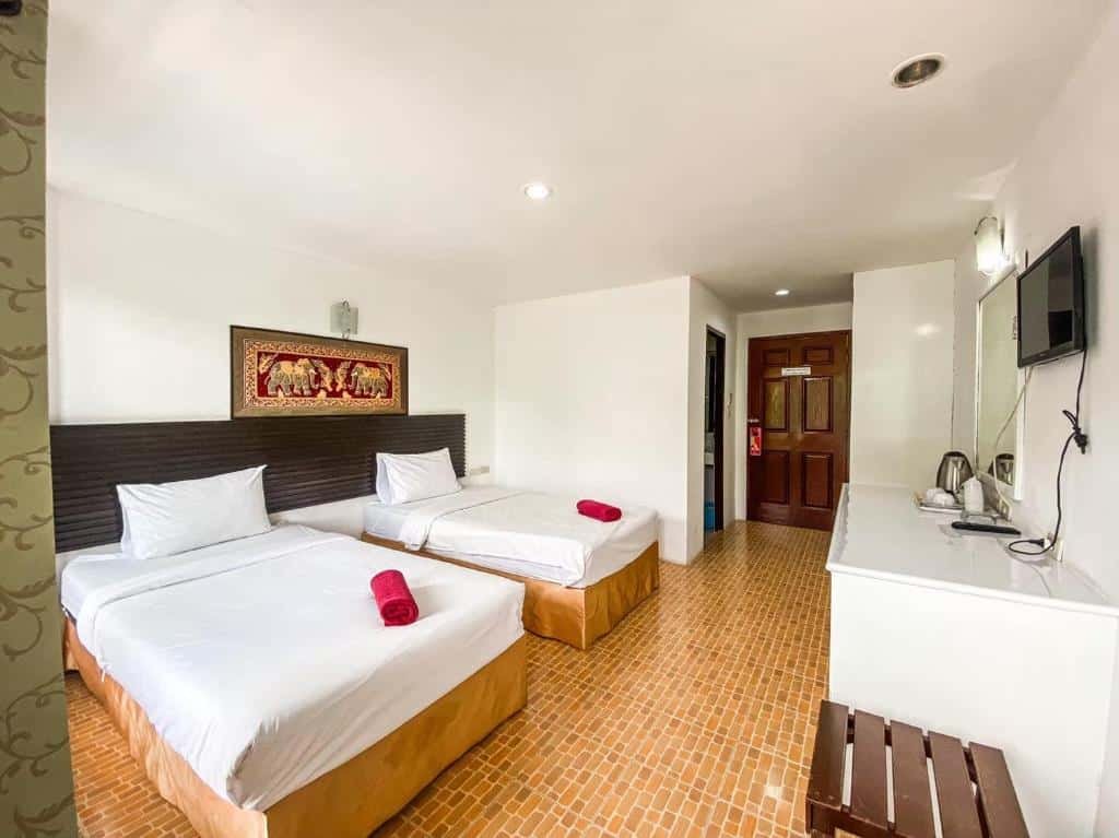 ห้องพัก ที่พักกระบี่ โรงแรมทันสมัยในกระบี่ที่พักมีเตียงเดี่ยว 2 เตียงพร้อม ที่พักกระบี่ ชุดเครื่องนอนสีขาว ผ้าเช็ดตัวสีแดง งานศิลปะฝาผนังมีสไตล์ ทีวี โต๊ะทำงานพร้อมกาต้มน้ำ และพื้นกระเบื้อง เหมาะสำหรับการเข้าพักของคุณที่รีสอร์ทกระบี่.