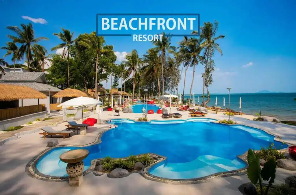ผ่อนคลายริมสระว่ายน้ำกลางแจ้งที่ โรงแรมกระบี่ ริมชายหาดของเรา รายล้อมไปด้วยเก้าอี้อาบแดด ร่มกันแดด และต้นปาล์ม ตั้งอยู่ท่ามกลางทิวทัศน์ทะเลอันสวยงามภายใต้ท้องฟ้าสีฟ้าใส.