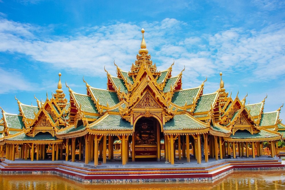 ศาลาไทยขนาดใหญ่ที่ประดับประดาอย่างวิจิตร มีหลังคาหลายชั้นสีเขียวและทอง ประดับด้วยงานแกะสลักอันสวยงาม และพระพุทธรูป ตั้งอยู่ท่ามกลางท้องฟ้าสีครามที่มีเมฆกระจายอยู่ประปราย—เป็นหนึ่งใน ที่เที่ยวใกล้กทม ไฮไลท์ของสถานที่ท่องเที่ยวในจังหวัดสตูล.