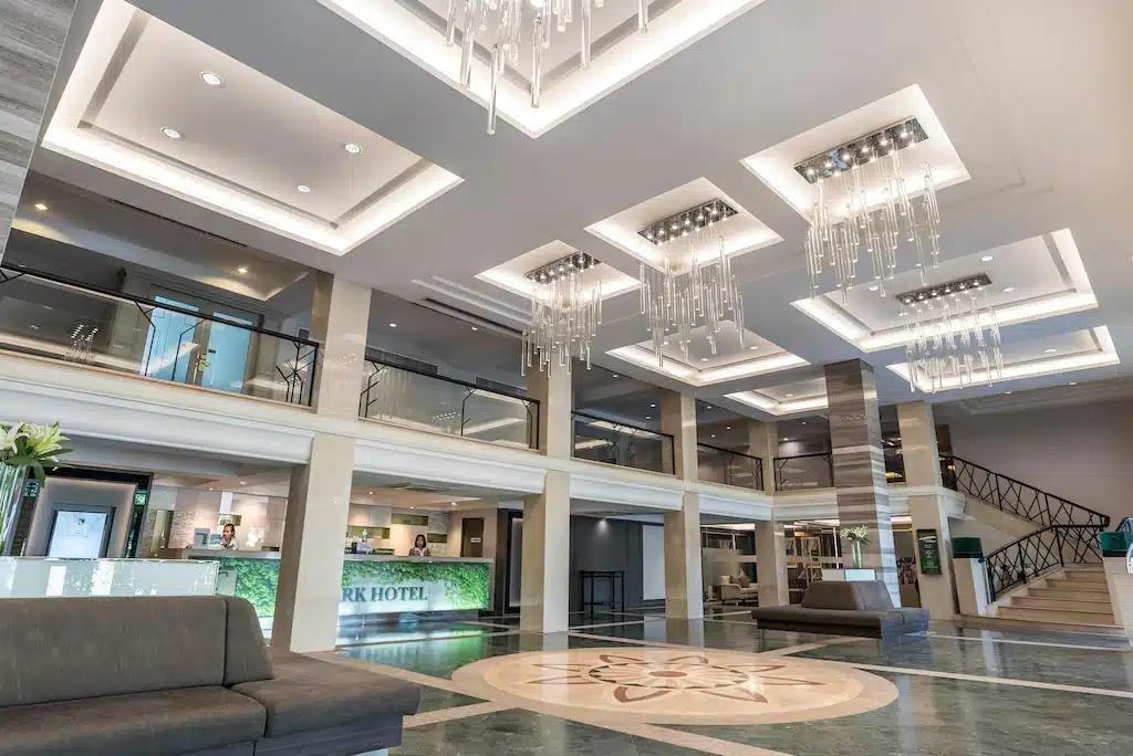 ล็อบบี้โรงแรมกว้างขวางพร้อมโคมไฟระย้าทันสมัย พื้นหินอ่อน  โรงแรมกรุงเทพ เคาน์เตอร์ต้อนรับ ราวบันไดกระจก และพื้นที่นั่งเล่นร่วมสมัย—ต้อนรับคุณสู่โรงแรม 5 ดาวในกรุงเทพฯ สำหรับการเข้าพักอันหรูหราของคุณ.