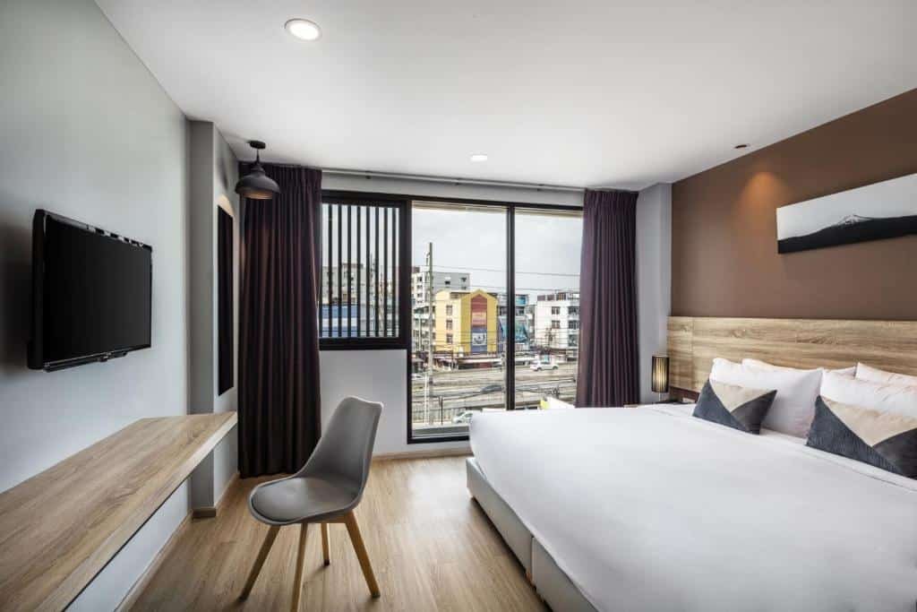 ห้องที่มีเตียงและเก้าอี้ เหมาะสำหรับการเข้าพักของคุณที่ โรงแรมในกรุงเทพ ฯ.