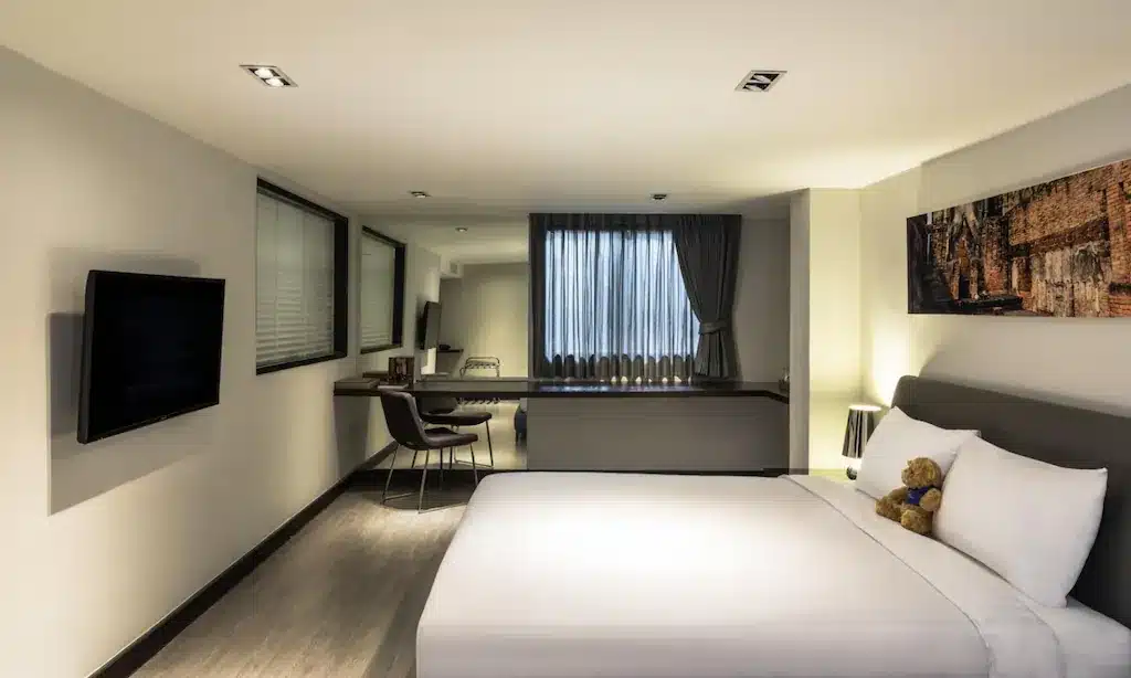 ห้องที่อบอุ่นพร้อมเตียงและโต๊ะทำงาน เหมาะสำหรับการเข้าพักของคุณที่ โรงแรมกรุงเทพ โรงแรมในกรุงเทพฯ.