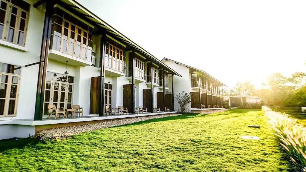 ที่พักสไตล์โมเดิร์นสองชั้นในจังหวัดน่าน มีหน้าต่างบานใหญ่และระเบียงที่มองเห็นสนามหญ้าที่ได้รับการดูแลอย่างดีภายใต้แสงแดดสดใส มอบความสะดวกสบายและความสะดวกสำหรับแขกที่มาเยือนจังหวัดน่าน.