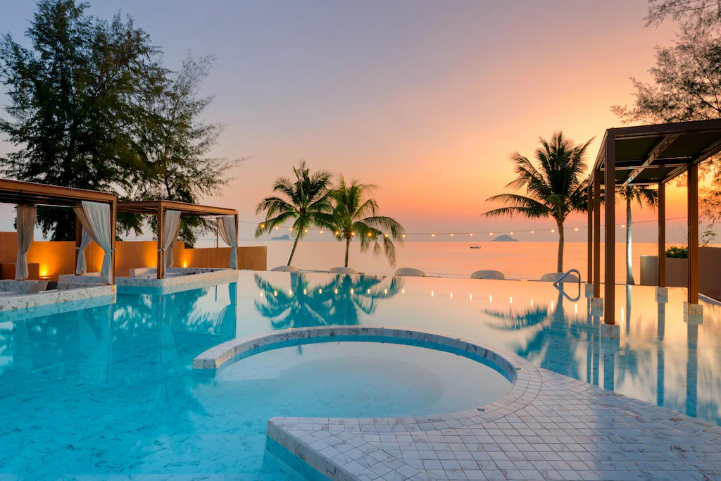 เพลิดเพลินกับสระว่ายน้ำแบบอินฟินิตี้พร้อมอ่างน้ำร้อนทรงกลม ศาลาพักผ่อนริมสระ ต้นปาล์ม และวิวทะเลอันงดงามยามพระอาทิตย์ตกดินที่ โรงแรมหัวหิน ของเรา—เหมาะอย่างยิ่งสำหรับการพักผ่อนในฝันของคุณที่ หัวหิน.