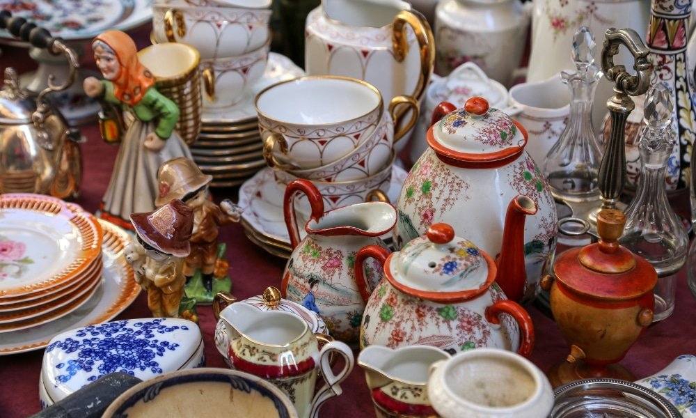 ชุดน้ำชาเซรามิกโบราณหลากหลายแบบ ประกอบด้วยกาน้ำชา ถ้วย ชาม ตุ๊กตา และเครื่องแก้ว จัดแสดงไว้บนโต๊ะอย่างสวยงาม—เหมาะอย่างยิ่งสำหรับการเพิ่มเสน่ห์ให้กับคอลเลกชันอยุธยาของคุณ หรือเป็นของที่ระลึกจากการเดินทางครั้งต่อไปของคุณที่อยุธยา.