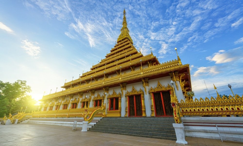 วัดพุทธสีทองหลายชั้นที่ประดับประดาอย่างวิจิตรตั้งอยู่ใต้ท้องฟ้าสีคราม—หนึ่งในสถานที่ท่องเที่ยวที่ต้องไปเยือนในขอนแก่นสำหรับนักเดินทางที่สำรวจสมบัติทางวัฒนธรรมของขอนแก่น.