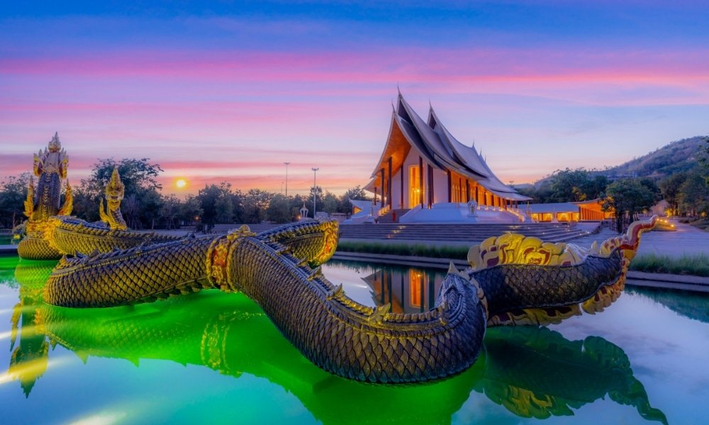 วัดที่มีหลังคาโค้งตั้งอยู่ด้านหลังสระน้ำที่ส่องแสงสีเขียว พร้อมด้วยรูปปั้นงูทองที่ตกแต่งอย่างวิจิตรบรรจง เมื่อพระอาทิตย์ตกดิน ทำให้ที่นี่กลายเป็นหนึ่งในสถานที่ท่องเที่ยวเพชรบูรณ์ที่น่าหลงใหลที่สุด สำหรับผู้ที่ต้องการมาสำรวจสถานที่ท่องเที่ยวเพชรบูรณ์อันน่าประทับใจ.