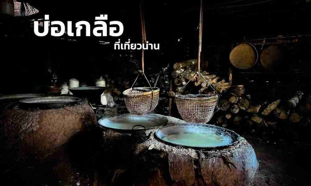 หม้อดินเผาขนาดใหญ่ที่มีตะกร้าแขวนอยู่ด้านบน ซึ่งใช้สำหรับการผลิตเกลือ ถูกจัดวางไว้ในห้องที่มีแสงสลัว พร้อมด้วยท่อนไม้ที่เรียงซ้อนกันอยู่ด้านหลัง ภาพฉากดั้งเดิมนี้เหมาะอย่างยิ่งสำหรับผู้ที่สนใจที่เที่ยวภาคเหนือ และถ่ายทอดเสน่ห์อันเป็นเอกลักษณ์ของภาคเหนือของไทยได้อย่างชัดเจน มีข้อความภาษาไทยปรากฏอยู่ที่มุมซ้ายบน.