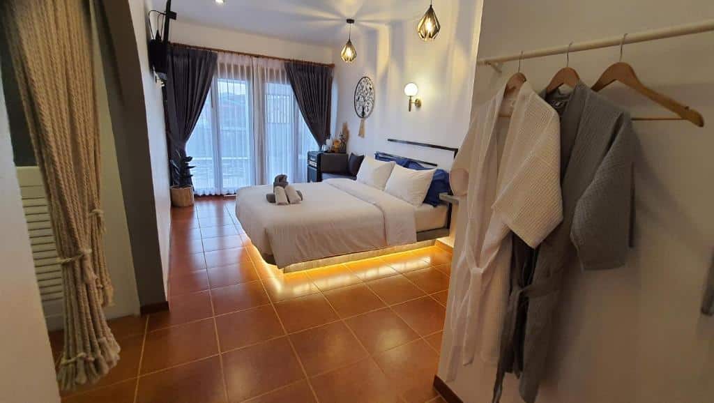 ห้องพักในโรงแรมที่มีเตียงควีนไซส์ เสื้อคลุมอาบน้ำแขวนสองตัว และระเบียงที่มีหน้าต่างสูงจากพื้นถึงเพดาน เหมาะอย่างยิ่งสำหรับการเข้าพักครั้งต่อไปของคุณที่เกาะล้าน.