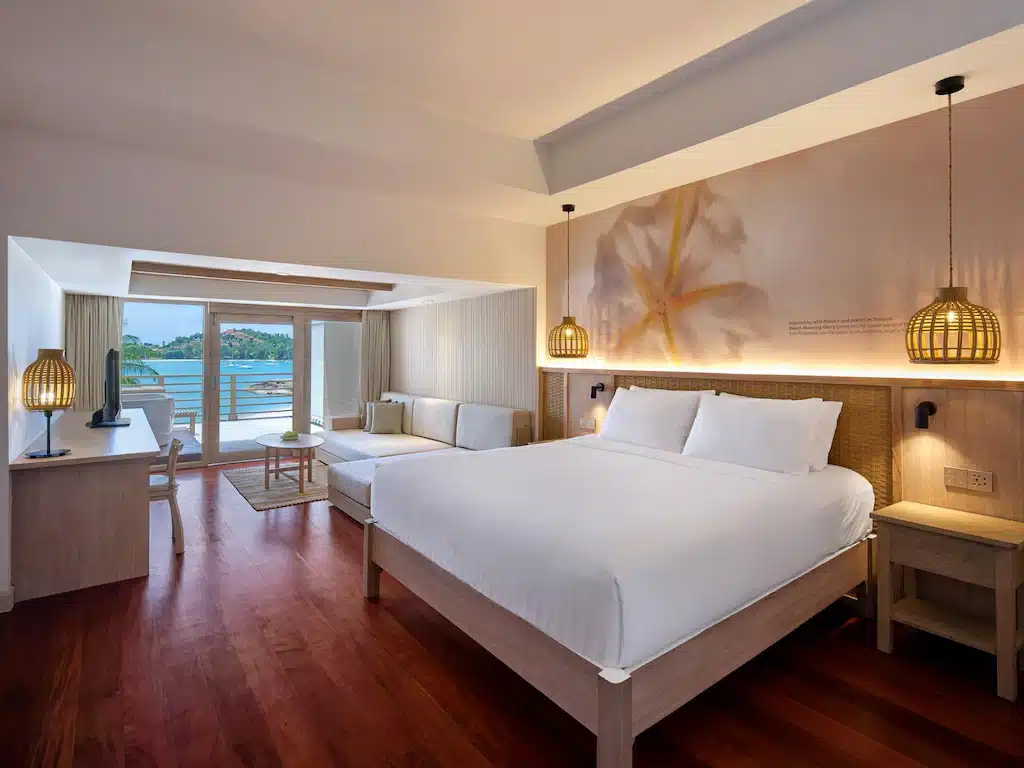 ห้องพักในโรงแรมแห่งนี้ ที่พักเกาะสมุย มีเตียงควีน โซฟา และระเบียงที่มองเห็นวิวทะเล.