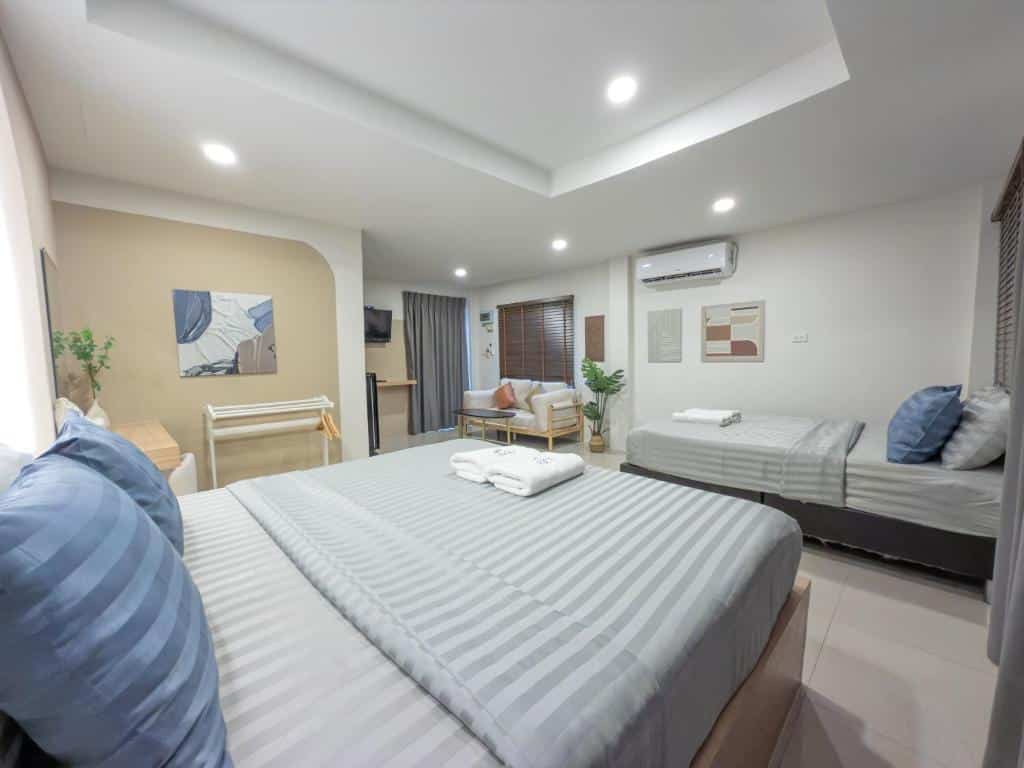ห้องพักในโรงแรมบนเกาะลาร์น โดยมีเตียงควีนอยู่ด้านหน้า และเตียงเดี่ยวสองเตียงอยู่ด้านหลัง.