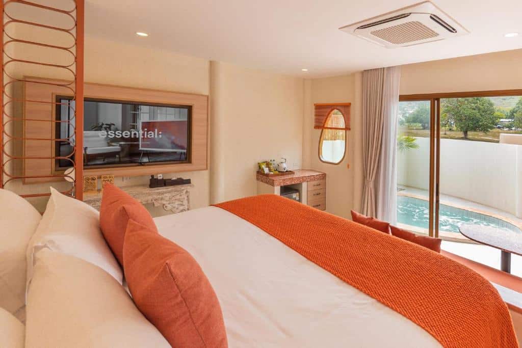 ห้องพักในโรงแรมที่มีเตียงคิงไซส์และโทรทัศน์ พร้อมประตูแก้วที่เปิดออกสู่ลานส่วนตัวและสระว่ายน้ำ ที่ที่พักราคาประหยัดบนเกาะลันแห่งนี้.
