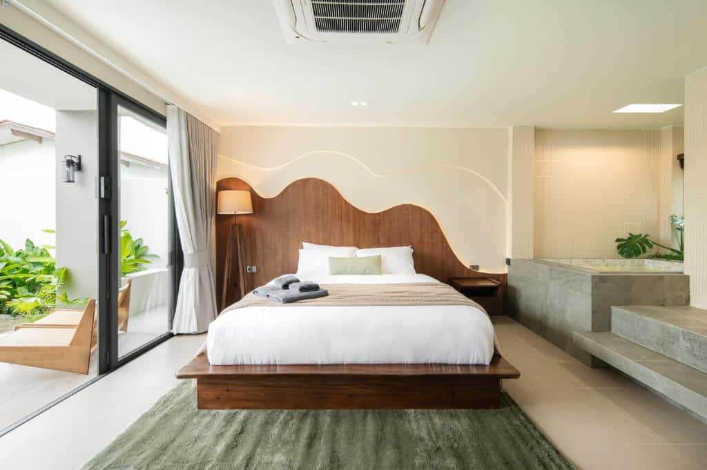 ห้องพักในโรงแรมแห่งนี้มีเตียงแบบแพลตฟอร์ม หัวเตียงไม้ที่มีดีไซน์เป็นคลื่นพร้อมไฟส่องสว่าง และอ่างอาบน้ำปูกระเบื้องหินที่อยู่ติดกัน ที่พักราคาประหยัดบนเกาะลันนี้.