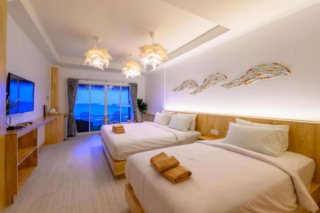 ห้องพักในโรงแรมที่มีเตียงควีนไซส์ 2 เตียง โทรทัศน์ และระเบียงที่มองเห็นวิวทะเล ที่ที่พักริมทะเลแห่งนี้บนเกาะลัน.