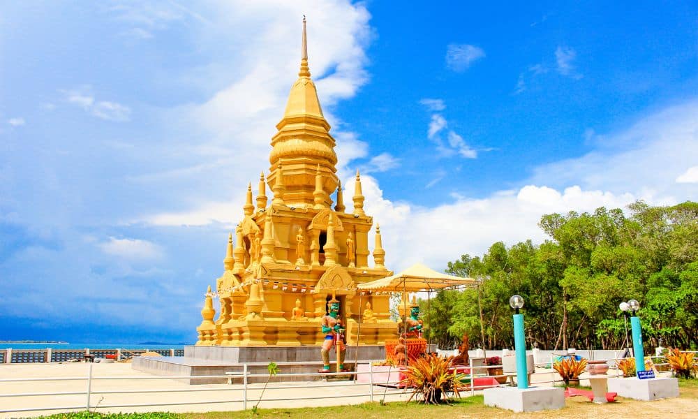เจดีย์สีทองสไตล์ไทยที่มีพระพุทธรูปขนาดเล็ก ตั้งอยู่ริมชายฝั่งทะเล โดยมีรูปปั้นผู้พิทักษ์สีเขียวสององค์อยู่ทั้งสองข้าง นับเป็นจุดเด่นของสถานที่ท่องเที่ยว ที่เที่ยวเกาะสมุย 2026 